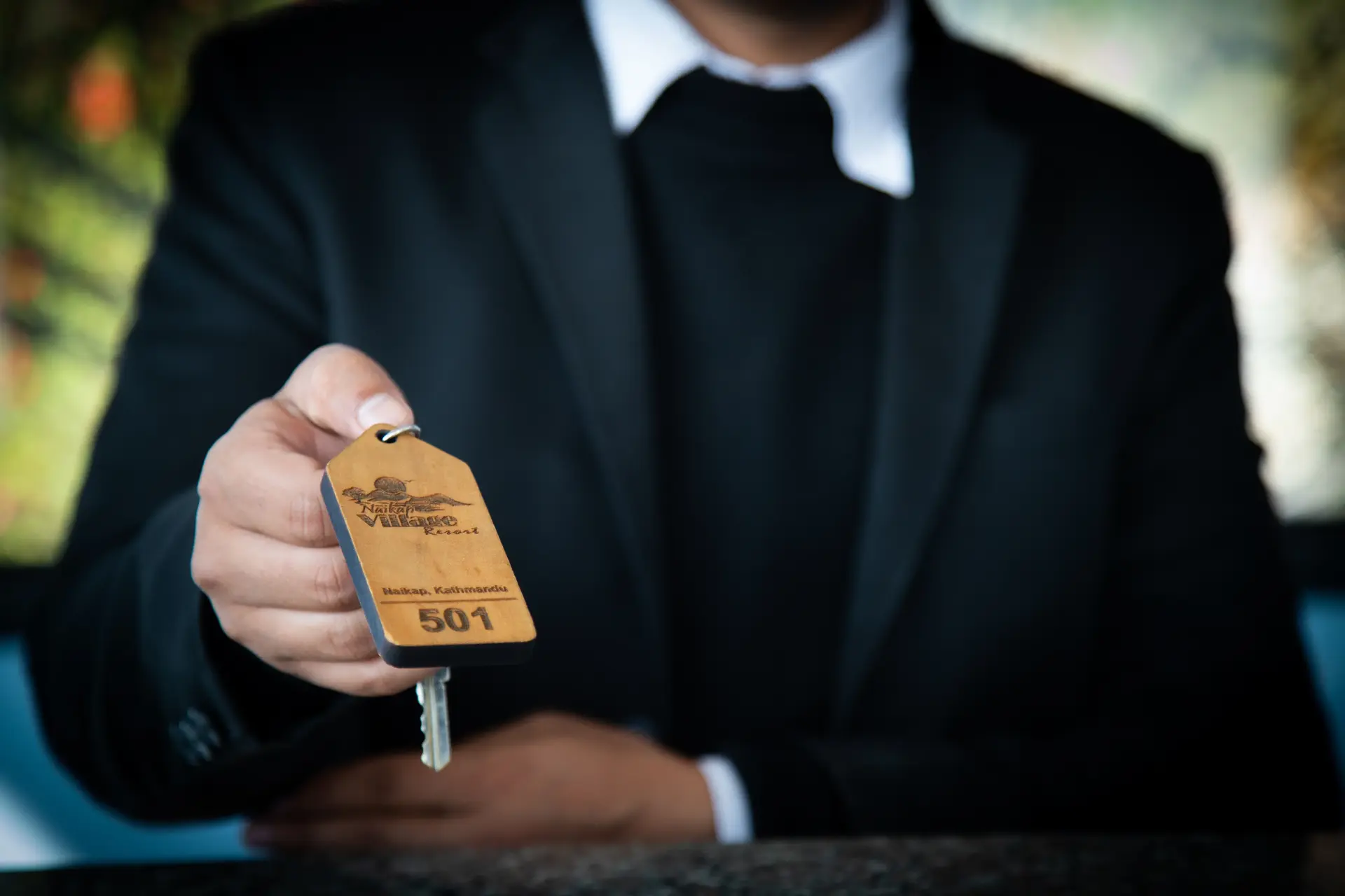 A person holding a key ring with logo